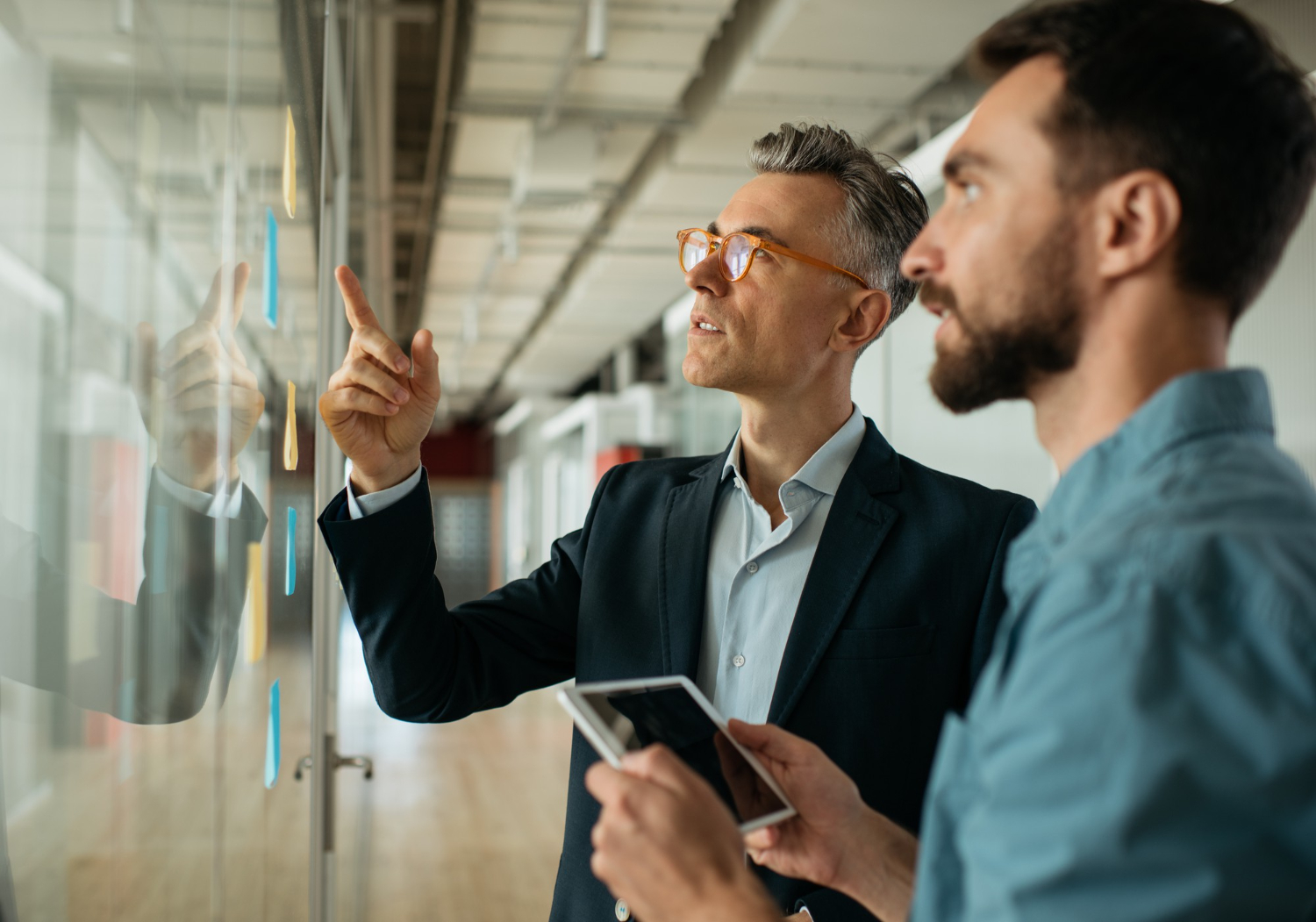 Two men are looking at a project plan.